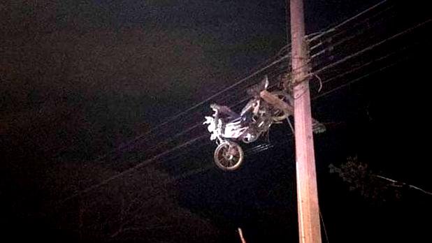 Motocycle Hangs In Powerlines In Thailand Credit